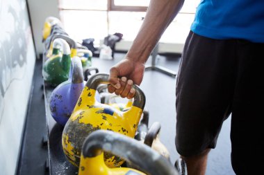 Spor salonunda egzersiz öncesi ağır kettlebell alarak activewear genç atlet Kas eli