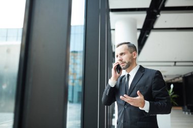 Bir müşteri danışmanlık ya da ortağına smartphone tarafından Havaalanı lounge alanında şık elbiseli ciddi broker