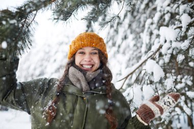 Bel kadar güzel çam ağaçları, kopya alanı altında kış ayakta açık havada poz mutlu genç kadın portresi