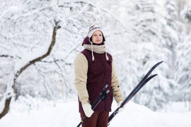 Güzel kış orman, kopya alanı poz tutan gülümseyen genç adam portresi kayaklar