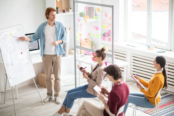 Ung Casual Coach Stående Whiteboard Och Pekar Tidningarna Samtidigt Förklarar — Stockfoto