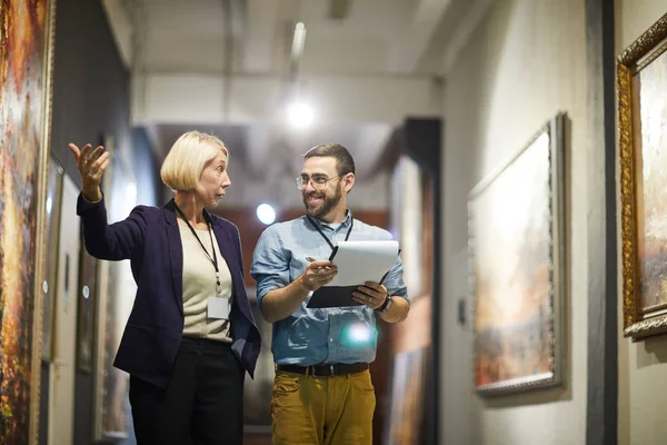 Portrait Two Cheerful Museum Workers Discussing Paintings Walking Art Gallery — Stock Photo, Image
