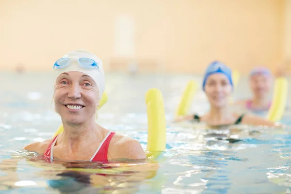 Reihe Aktiver Seniorinnen Beim Training Schwimmbad Die Poolnudeln Der Hand — Stockfoto