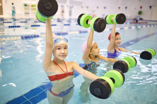 Gruppe Kleiner Mädchen Badeanzug Stehend Und Mit Kurzhanteln Schwimmbad Trainierend — Stockfoto