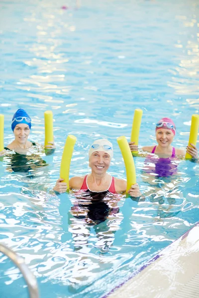 Gruppe Aktiver Seniorinnen Die Schwimmbad Poolnudeln Halten Und Lächeln Kopierraum — Stockfoto