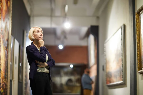 Portret Van Peinzende Volwassen Vrouw Kijken Naar Schilderijen Staan Art — Stockfoto