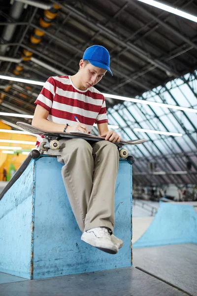 Young Boy Skateboard Sitting Stadium Writing Something Break Workouts — Stock Photo, Image