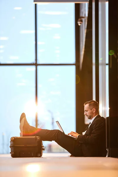 Empresário Sério Que Concentra Rede Enquanto Está Sentado Chão Lounge — Fotografia de Stock