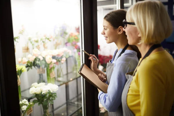 Midja Upp Porträtt Två Kvinnliga Florister Holding Urklipp Tittar Blommor — Stockfoto