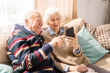 Evde aile ile görüntülü sohbet birlikte akıllı telefon kullanarak sevimli üst düzey çift portresi, kopya alanı