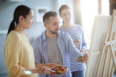 Genç adam onun öğrencileri ile paylaşıyor sırasında resimle suluboya veya guaş konsantre
