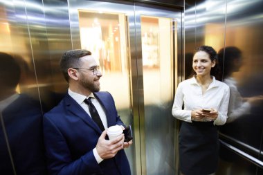 Asansör içinde akıllı telefonlar kullanırken birbirlerine bakarak harika insanlar mutlu Millennials