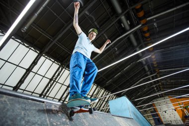 Parkour uygulama sırasında aşağı doğru hareket ederken gemide duran casualwear aktif genç adam