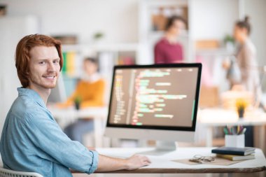 Genç başarılı tasarımcı veya programcı size Resepsiyon tarafından oturan ve online veri kod çözme bakıyor