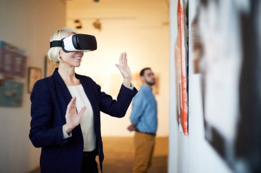 Belden yukarı çağdaş gülümseyen kadın giyiyor Vr kulaklık Sanat Galerisi'nde, kopya alanı portresi