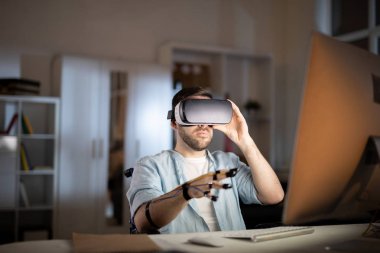 İşadamı vr kulaklık ve sensörler önünde ofiste bilgisayar monitörü Masası tarafından oturan parmak uçları