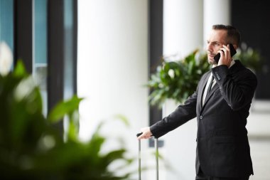 Genç ciddi broker veya uçuş için bekleme telefonda resmi kıyafeti danışmanlık istemcisindeki Aracısı