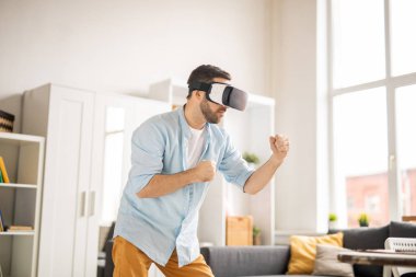 Süre odasında sanal rakip ile mücadele kollarını önünde kendini tutmak vr kulaklık ile genç casual adam
