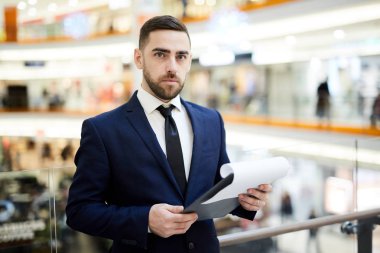 Elinde belge okurken zarif takım elbise size bakıyor genç ciddi işadamı