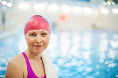 Havuzda aktif bir kadının baş ve omuz portresi mutlu bir şekilde gülümseyerek ve kameraya bakarak, kopya alanı