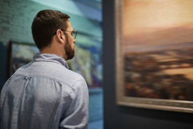 Modern Sanat Galerisi veya Müzesi, kopya alanı resimleri bakarak genç sakallı adam portresi arkadan görünüm
