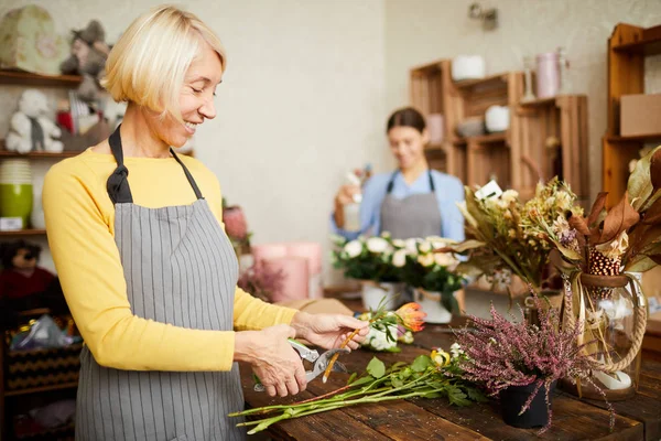 Side View Porträtt Leende Kvinnliga Florist Skärande Blomma Stjälkar Medan — Stockfoto