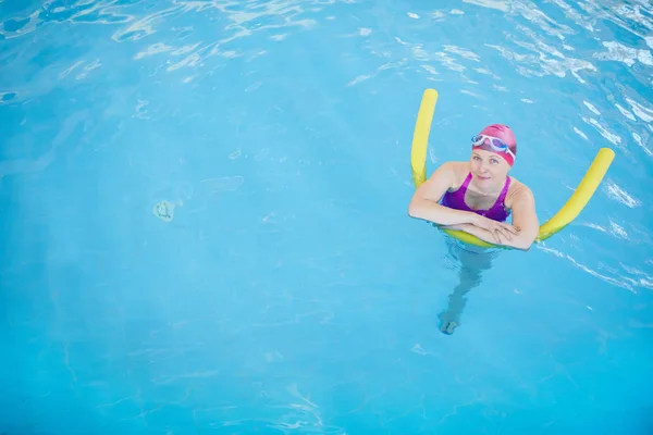 プールで泳いでカメラを見て コピースペースの幸せな先輩女性のトップビューの肖像画 — ストック写真