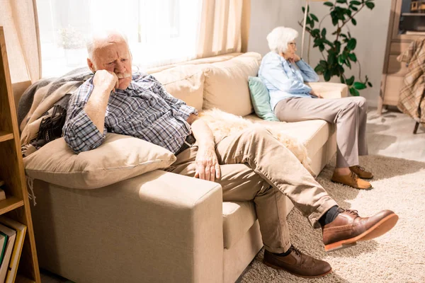 Ganzkörperporträt Moderner Senioren Die Auf Gegenüberliegenden Seiten Der Couch Sitzen — Stockfoto