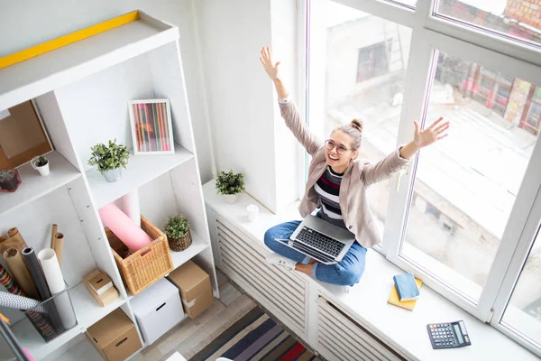 Extatisch Zakenvrouw Met Laptop Verhogen Haar Armen Terwijl Zittend Vensterbank — Stockfoto