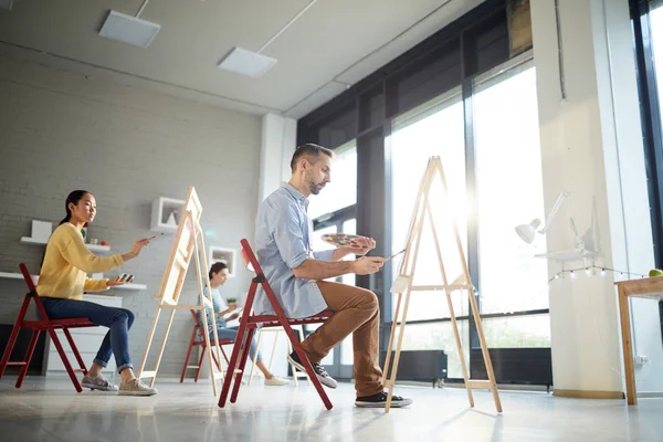 Grupo Estudiantes Sentados Frente Caballetes Concentrados Pintura Lección Estudio Arte — Foto de Stock