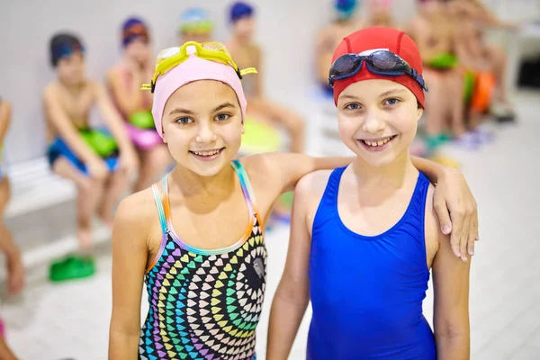 Portret Dwóch Uśmiechniętych Dziewczynek Strój Kąpielowy Stojący Obejmując Podczas Lekcji — Zdjęcie stockowe