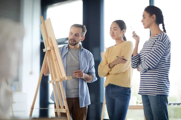 Duas Meninas Casualwear Ouvindo Seu Professor Explicando Alguns Erros Pintura — Fotografia de Stock