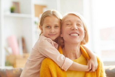 Olgun kadın kucaklayan ve kamera gülümseyen sevimli küçük kız Portresi, kopya alanı