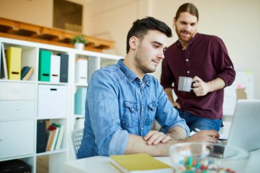 İki genç gündelik çalışanlar net tarama ve yeni fikirler ararken dizüstü ekran bakarak