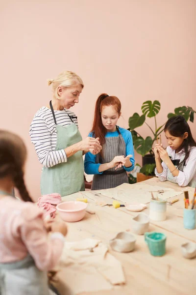 成熟した女性教師とのワークショップで手作りの陶磁器を作る子供たちの肖像画 コピースペース — ストック写真