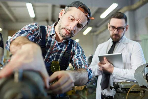 Portrait of  mature mechanic repairing machines in factory workshop, copy space