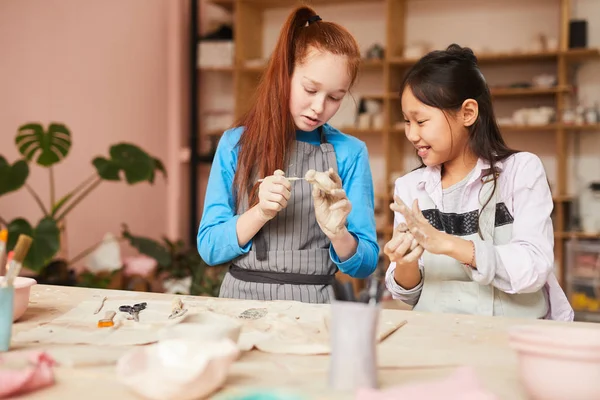 陶芸教室で手作りの陶磁器を作りながら粘土を造る2人の少女の肖像画 コピースペース — ストック写真
