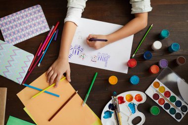 Yukarıda, sanat sınıfında iki kedinin resmini çizen tanınmayan küçük kızın yakın çekimi, kopya alanı