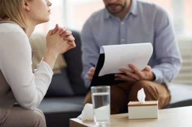 Psikologa açıklamadan önce sorunlarına konsantre olan genç bir danışman hastası.