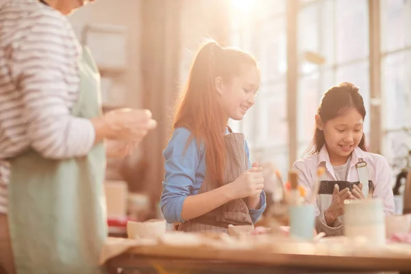 太陽光に照らされた美術教室で手作りの陶器を作る子どもたちの多民族グループ コピースペース — ストック写真