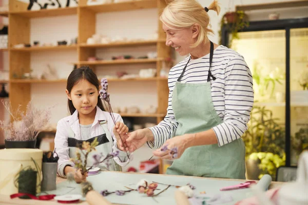 小さなアジアの女の子と花の組成物を作成笑顔成熟した女性の肖像画 コピースペース — ストック写真