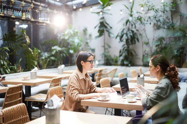 Mujeres Negocios Serias Reflexivas Sentadas Mesa Cafetería Con Interior Tropical — Foto de Stock