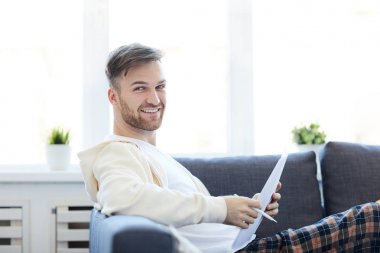 Kanepede yatarken kameraya bakan yakışıklı genç adamın yan görünüm portresi, kopya alanı