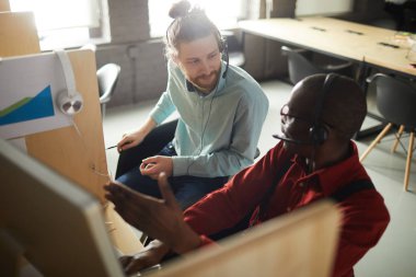Kabinlerde çalışırken iş arkadaşıyla konuşan Afro-Amerikan yardım hattı operatörünün portresi, kopya alanı