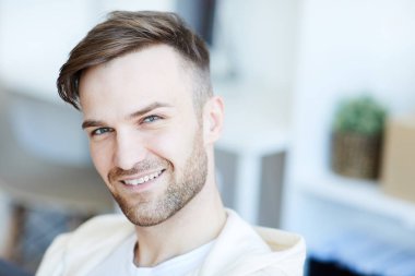 Kamera ve gülümseyen bakarak kısa sakallı yakışıklı genç adamın baş ve omuzportresi, kopya alanı