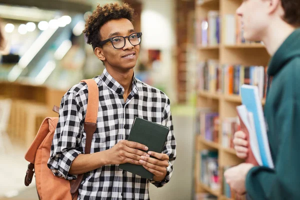 Treści Ciekawy African American Facet Okularach Stojących Bibliotece Trzymając Książkę — Zdjęcie stockowe