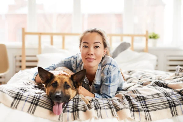 Retrato Mujer Asiática Sonriente Abrazando Perro Acostado Cama Mirando Cámara —  Fotos de Stock