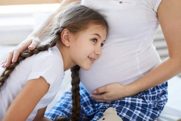 Retrato Una Linda Niña Escuchando Vientre Embarazada Una Madre Irreconocible —  Fotos de Stock