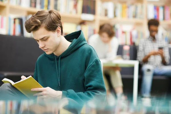 Sério Estudante Concentrado Cara Capuz Sentado Livraria Moderna Livro Leitura — Fotografia de Stock