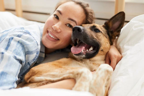 Retrato Sorrir Mulher Asiática Abraçando Cão Deitado Cama Juntos Olhando — Fotografia de Stock